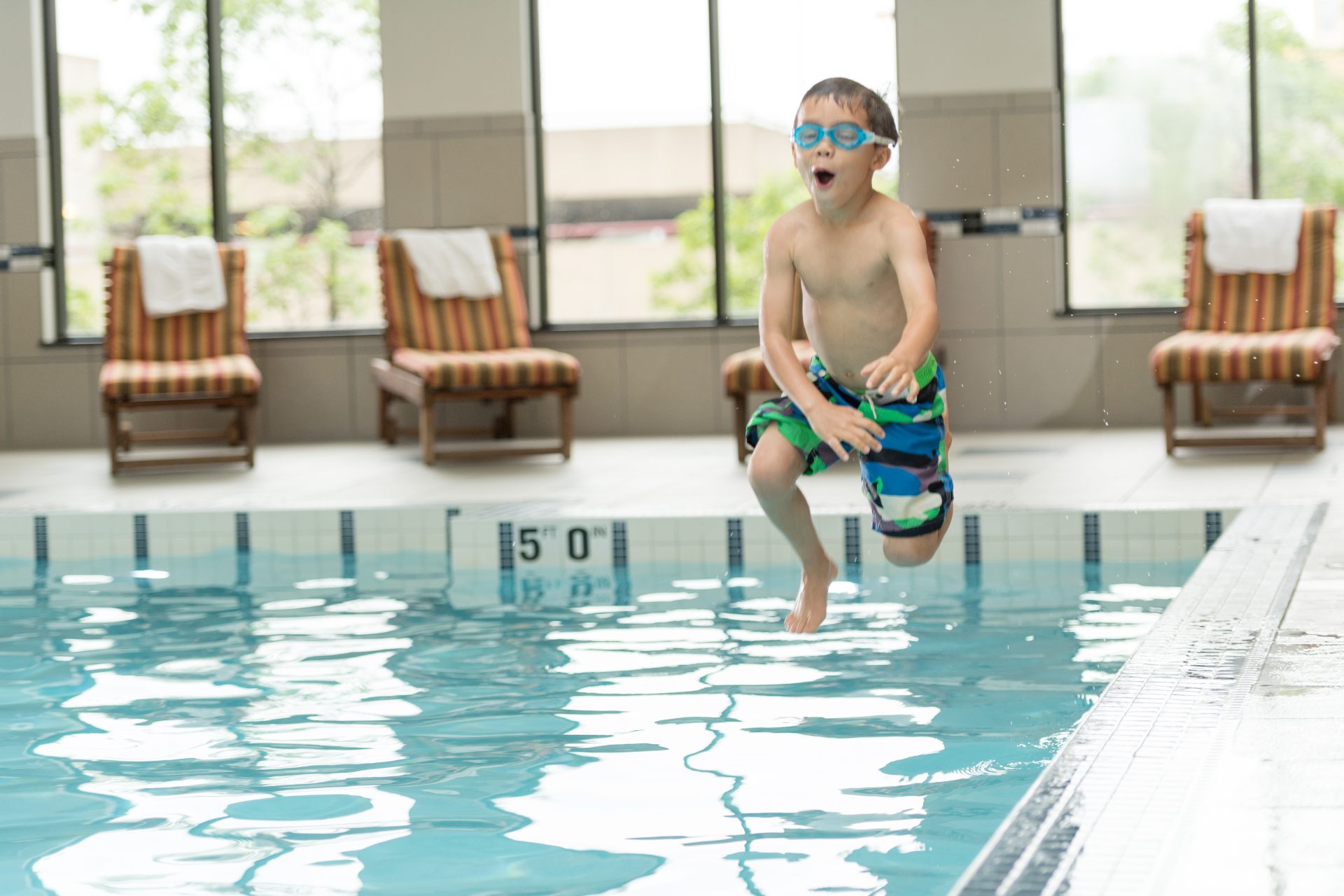 Child having fun jumping into the hotel pool