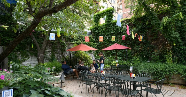A group of friends enjoying a meal and drinks in the Beer Garden at the downtown location of the Great Dane Pub.