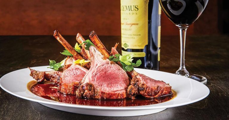 A plate of steak and wine from Johnny Delmonico's showcasing what to expect from the upscale menu.