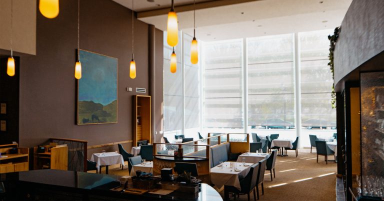 The elegant dining room at L’Etoile in Madison, featuring refined table settings, warm lighting, and a sophisticated atmosphere for an upscale dining experience.