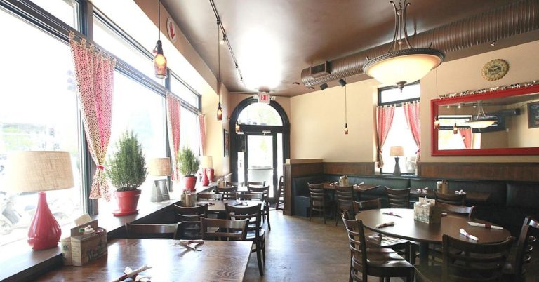 The cozy and charming dining room of Tipsy Cow in downtown Madison featuring homey cowprint curtains and decor having to do with dairy and cows.